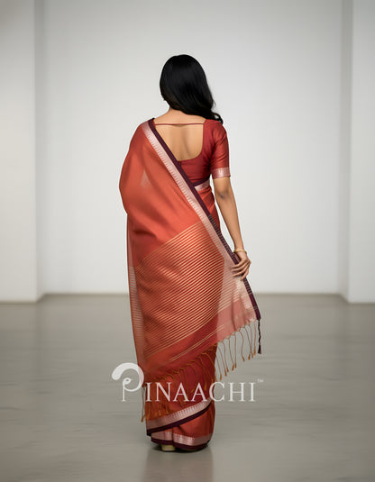 Elegant coral blush mul tissue saree with intricate draping and a stylish border from Pinaachi