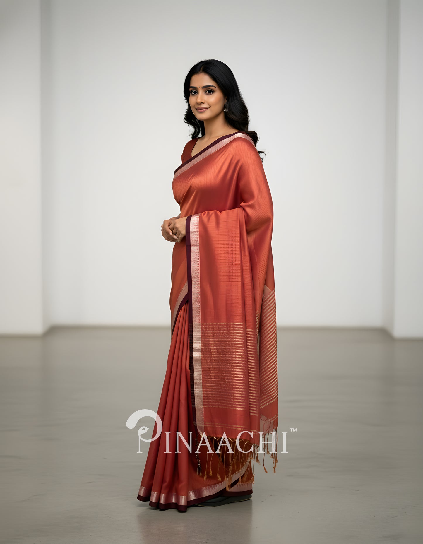 Elegant coral blush mul tissue saree by Pinaachi with a beautiful drape and textured border