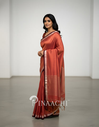 Elegant coral blush mul tissue saree by Pinaachi with a beautiful drape and textured border