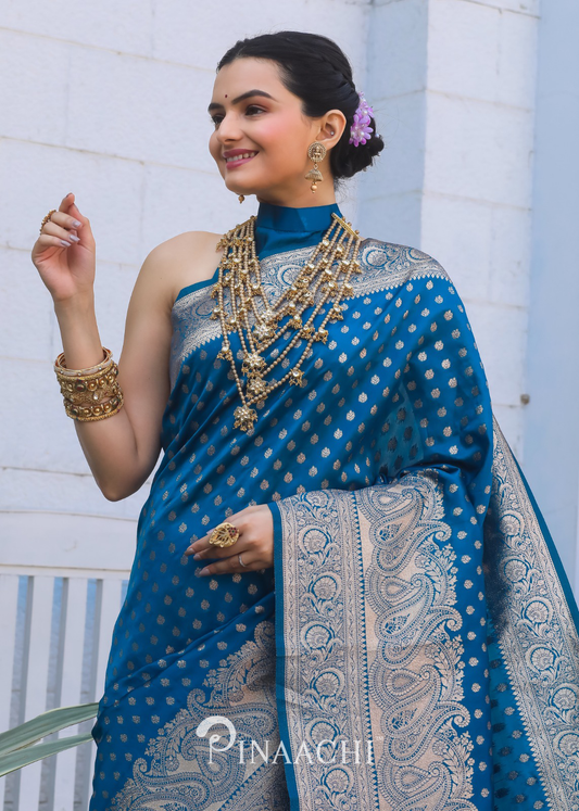 Pinaachi Firozi Banarasi silk saree with intricate gold designs worn by a smiling woman with traditional jewelry