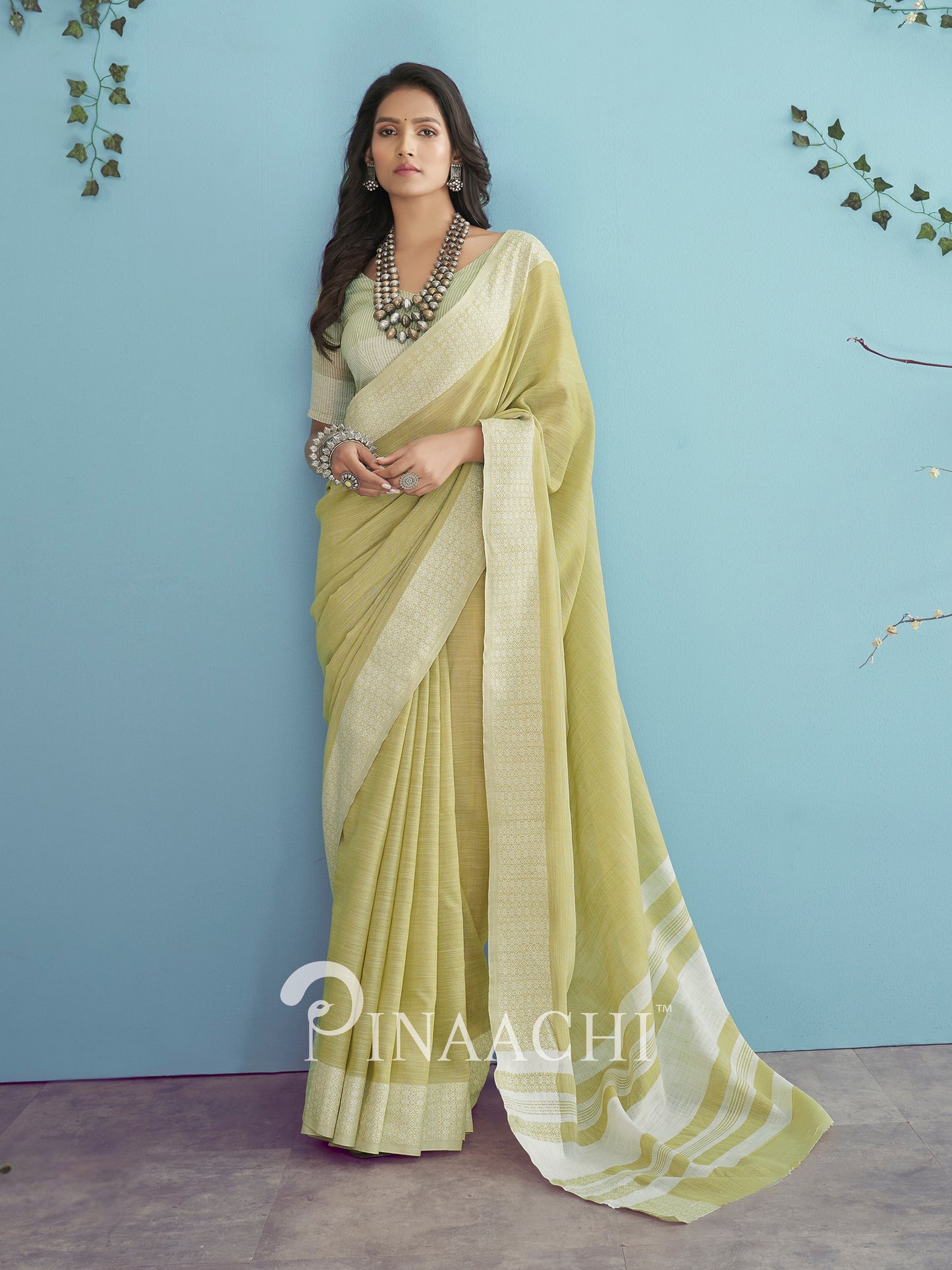 Elegant green linen saree by Pinaachi with a stylish drape and subtle shimmer