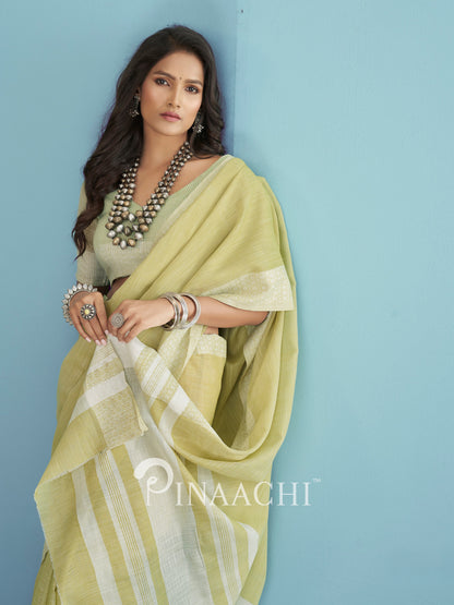 Elegant woman draped in a green linen saree styled with statement jewelry and a blouse