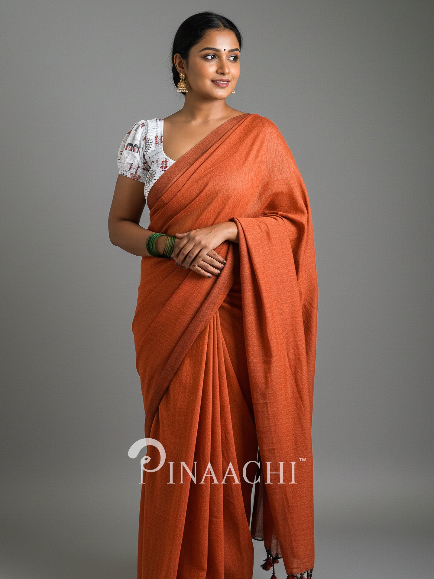 Elegant woman in a handspun rust orange cotton saree showcasing traditional style and comfort