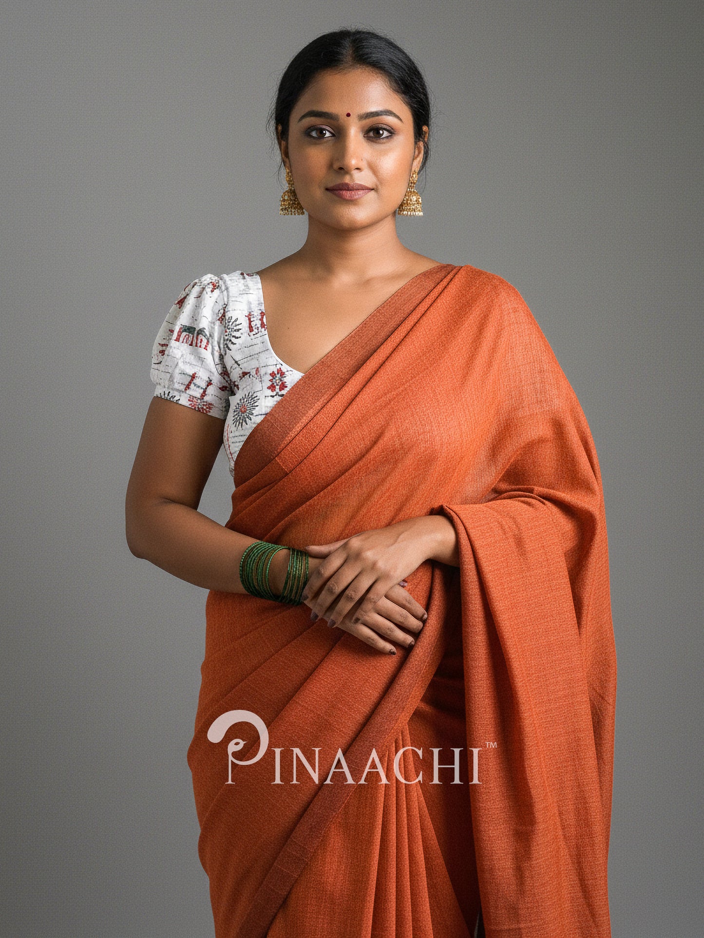 Elegant model wearing a handspun rust orange cotton saree styled with a traditional blouse