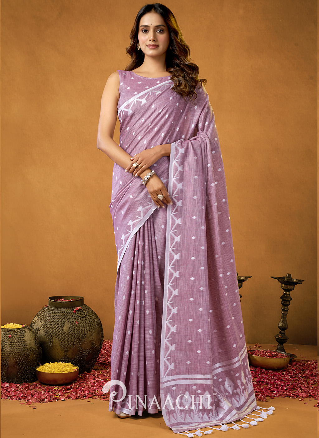 Elegant woman wearing a light purple pinaachi jamdani saree with white geometric patterns and tassels