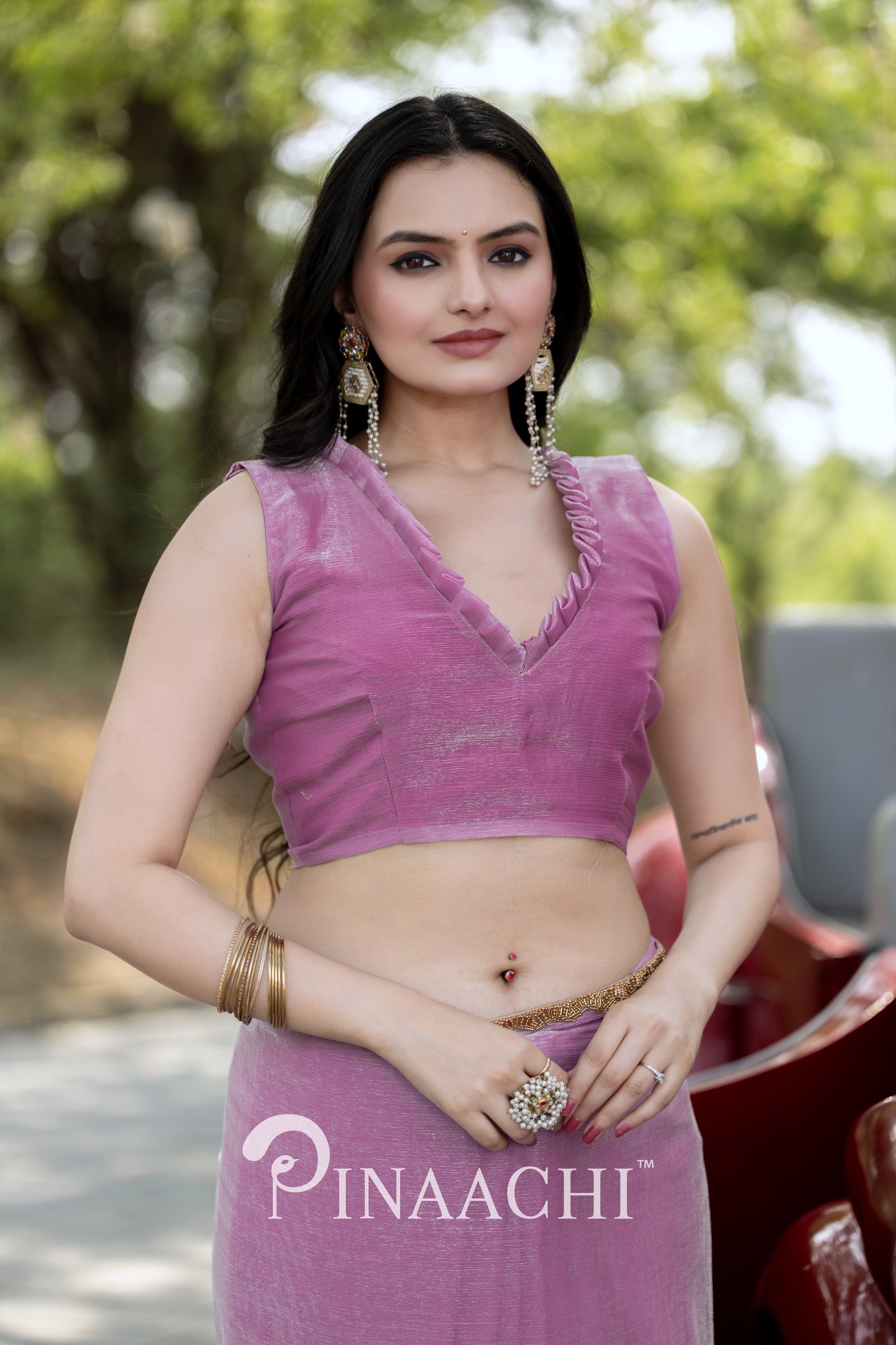 Woman wearing Pinaachi lavender chiffon saree with sleeveless blouse and traditional jewelry outdoors