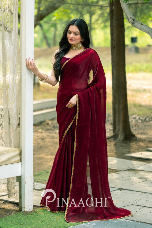 Elegant Pinaachi maroon chiffon saree worn by woman with gold border detail and matching jewelry