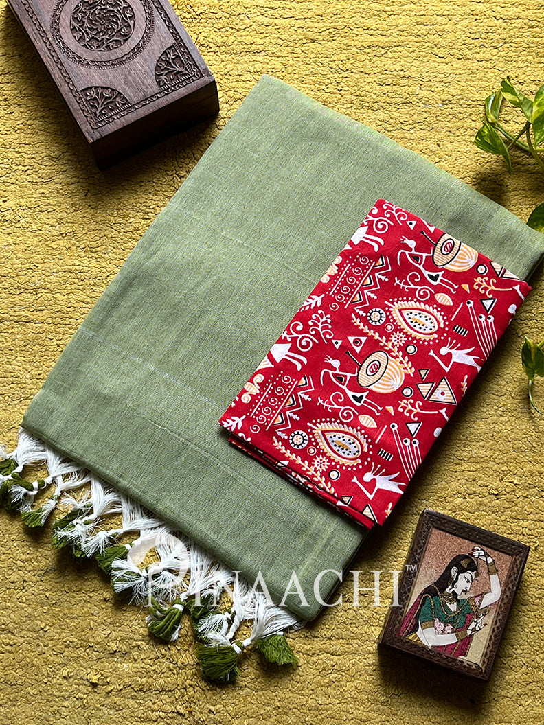 Pinaachi mint green cotton saree folded with a vibrant red patterned blouse piece on a textured background