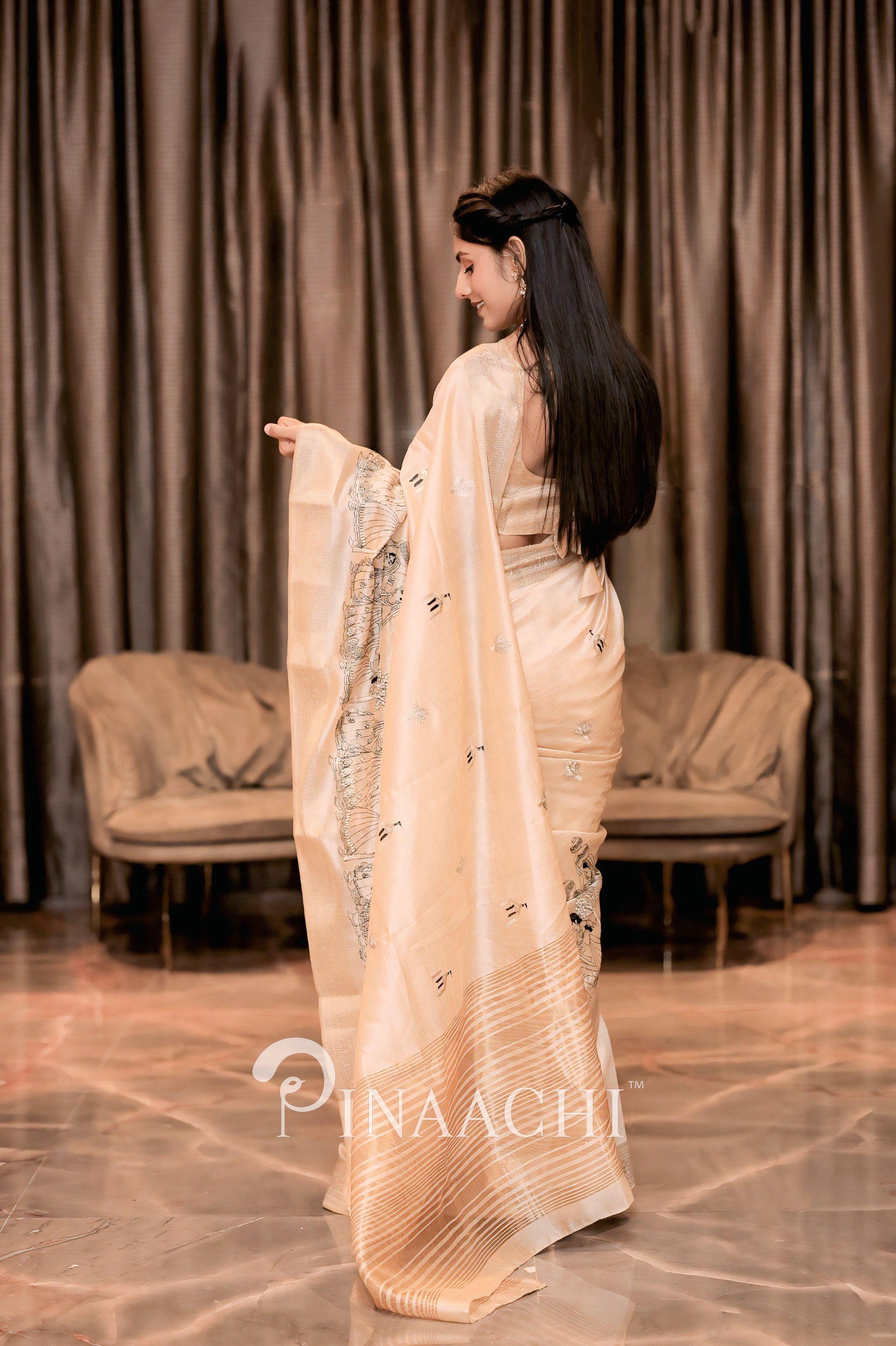 Elegant off-white tussar silk saree by Pinaachi, featuring intricate designs and a graceful drape
