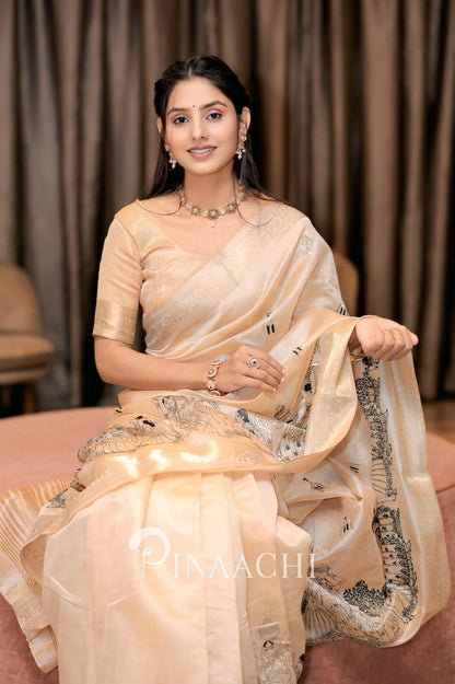 Elegant woman wearing an off-white tussar silk saree adorned with intricate embroidery