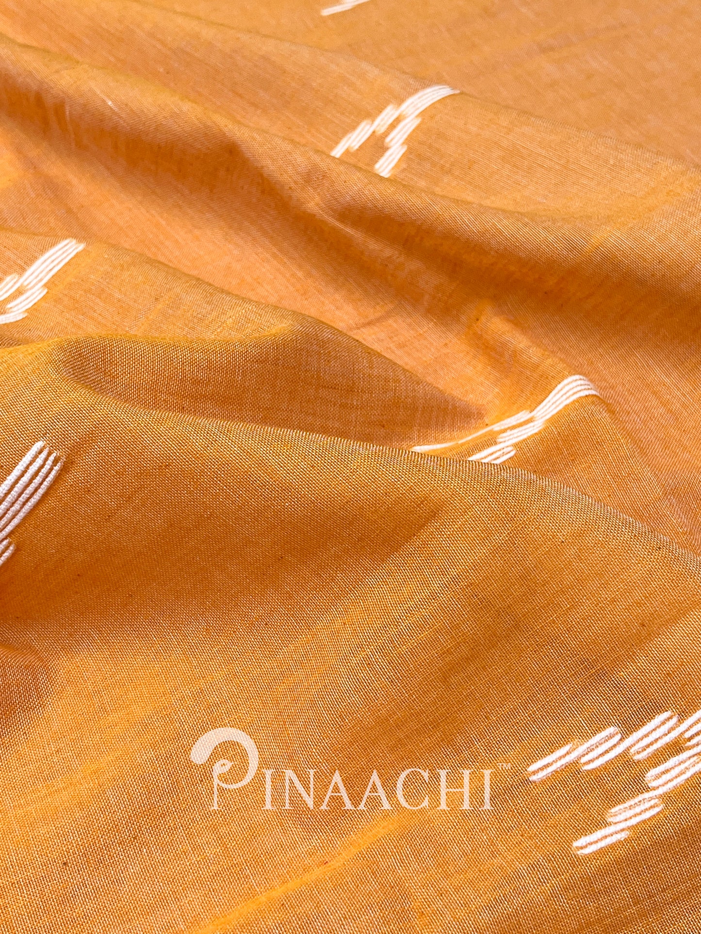 Pinaachi orange mulmul jamdani saree made from soft mulmul fabric with intricate weaving details