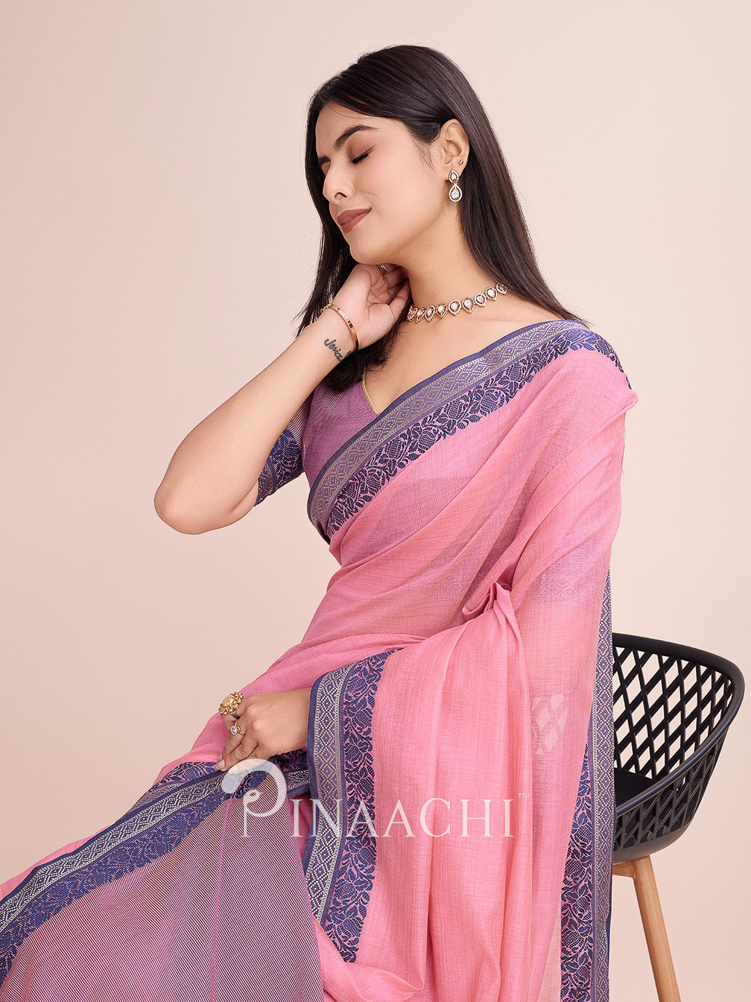Pinaachi pink cotton saree with woven border, elegantly draped for a chic look