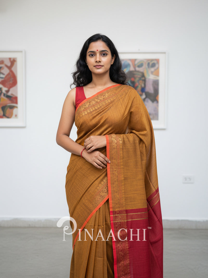 Pinaachi smoked mustard cotton silk saree with intricate borders and elegant draping