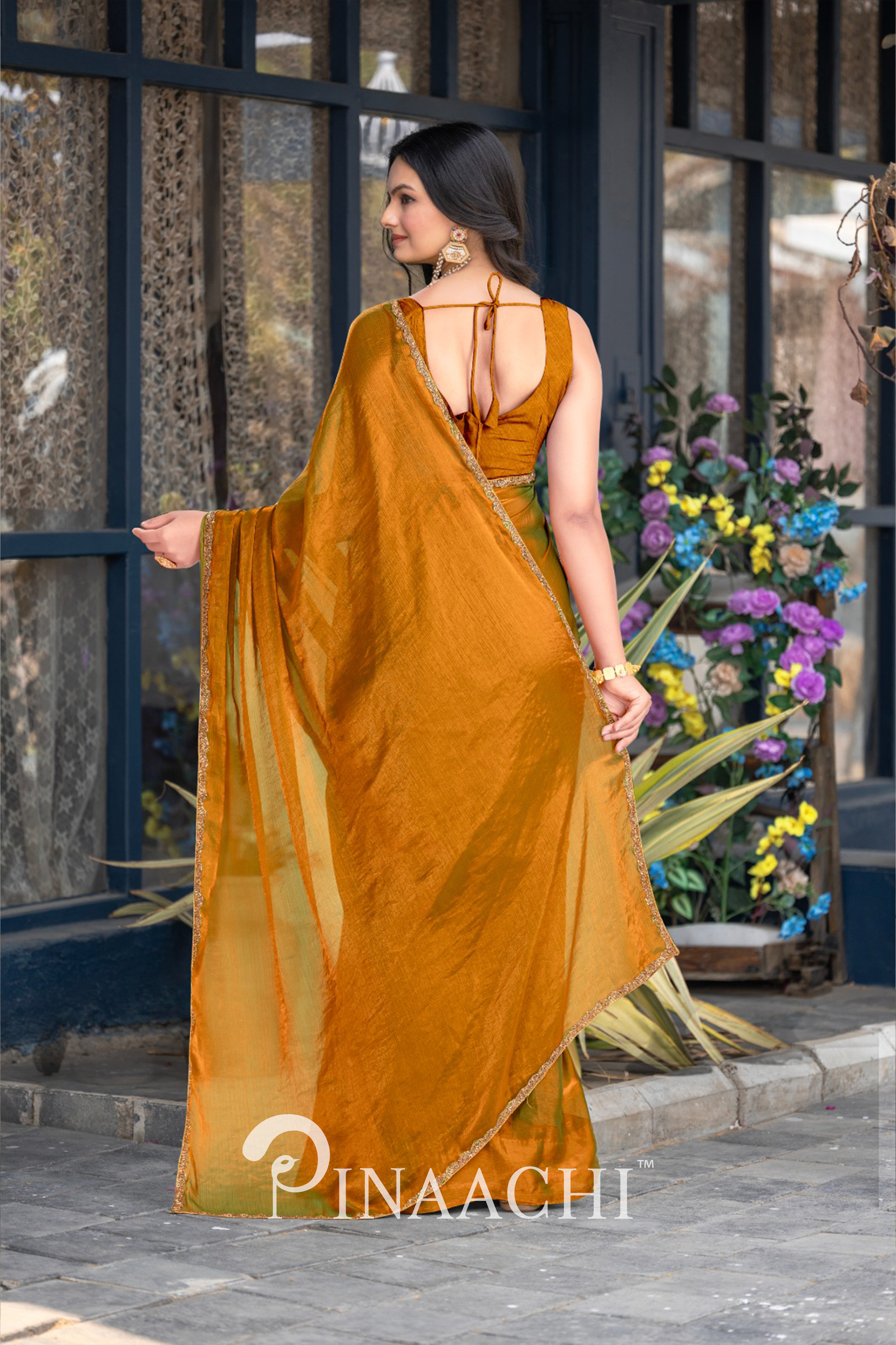 Woman wearing a pinaachi solid gold chiffon saree with detailed back design and elegant drape
