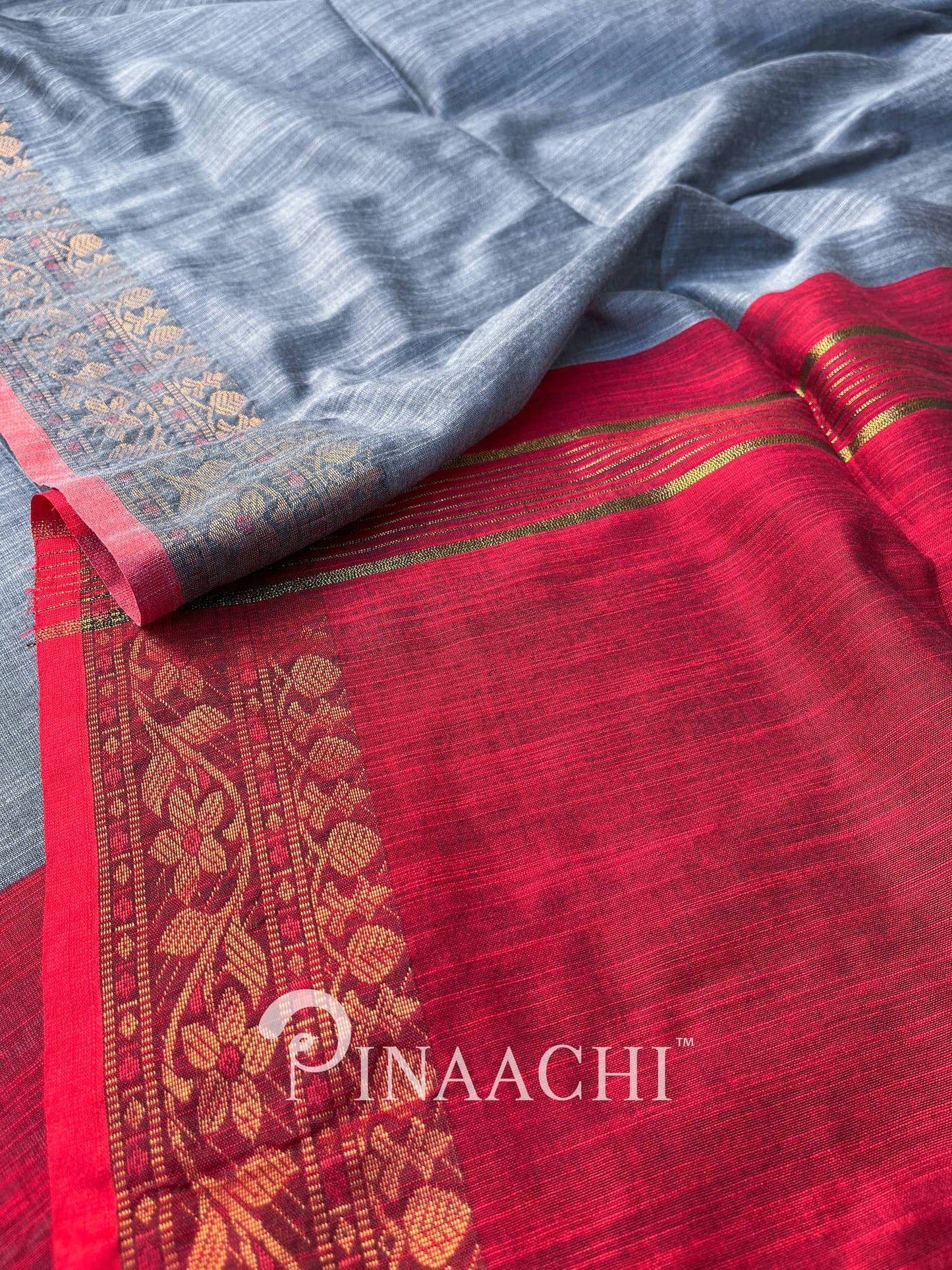 Pinaachi steel blue cotton silk saree with intricate red border and floral design