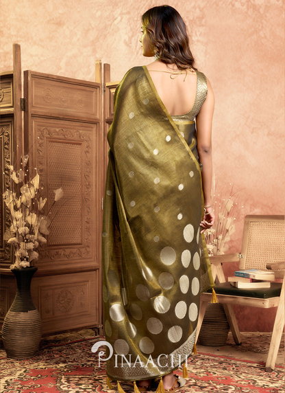 Elegant green pinaachi tissue silk saree online with gold polka dot design worn by a model indoors