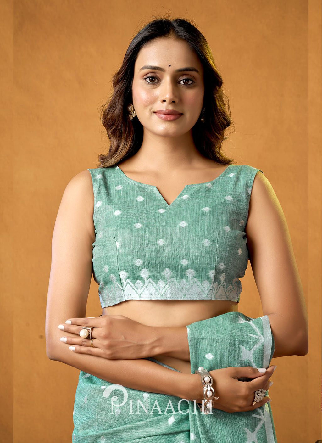 Woman wearing a green Rama Cotton Jamdani Saree by Pinaachi with traditional white patterns