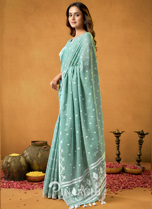 Woman wearing Pinaachi Rama Cotton Jamdani Saree in pastel green with white motifs and tassels