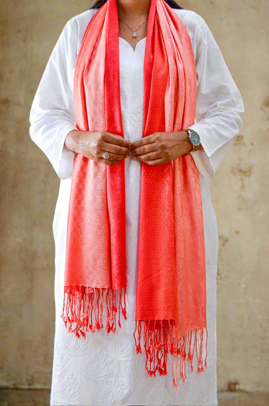 Elegant red gradient jacquard stole draped elegantly over a white outfit with fringed edges