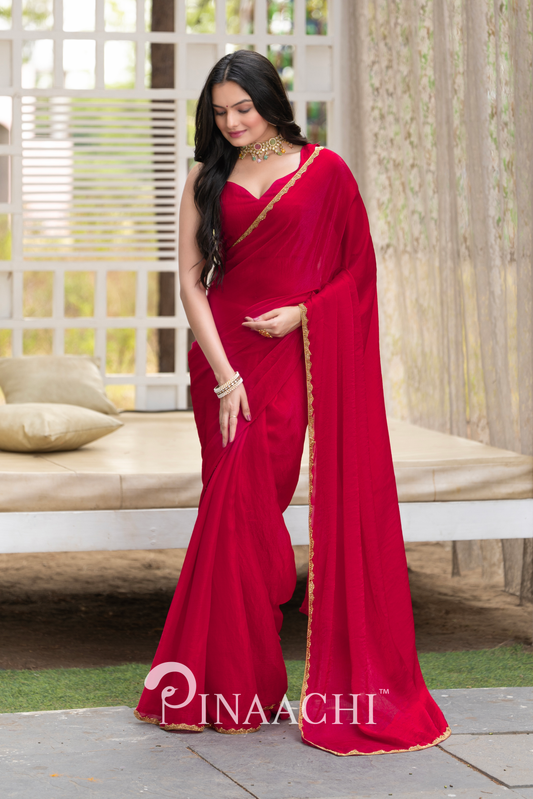 Pinaachi solid cherry red chiffon saree worn by model with golden border and matching blouse
