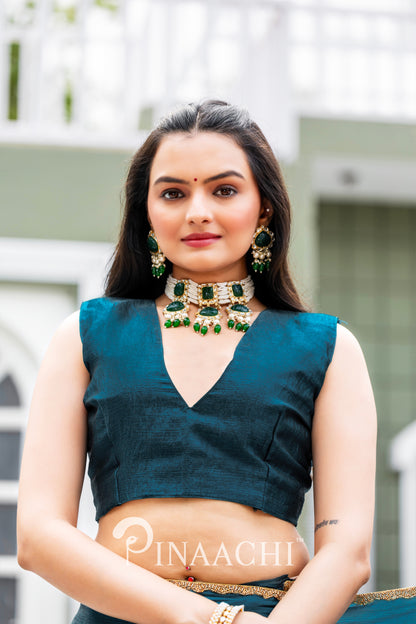 Woman wearing Pinaachi Morpich chiffon saree with a deep teal blouse and traditional green jewelry