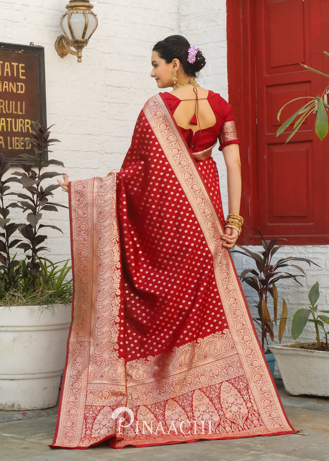 Pinaachi Red Banarasi Silk Saree worn by woman with traditional gold detailing and intricate border design